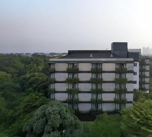a tall white building with green plants on it at Park 5 Cilandak in Jakarta