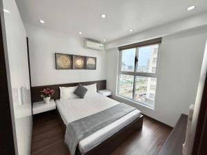 a bedroom with a bed and a large window at Homestay Newlife Tower Vipp in Ha Long