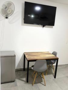 a table with two chairs and a television on a wall at Diplastic House in Sincelejo