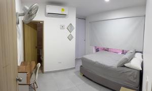 a bedroom with a bed and a desk and a fan at Diplastic House in Sincelejo