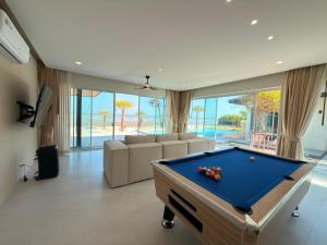 a living room with a pool table in a house at Wind Haus Beachfront Villa in Ban Hat Chao Samran