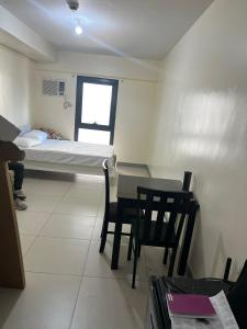 a room with a bed and a table and chairs at Studio 7 in Manila