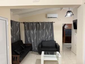 a living room with a black couch and a table at departamento luck in Puerto Iguazú