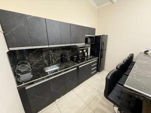a kitchen with black cabinets and a black refrigerator at departamento luck in Puerto Iguazú +7 photos