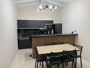 a kitchen with a wooden table and black chairs at departamento luck in Puerto Iguazú