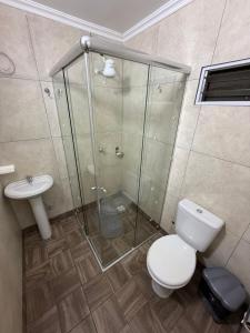 a bathroom with a shower and a toilet and a sink at departamento luck in Puerto Iguazú