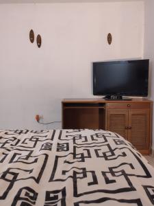 a bedroom with a bed and a flat screen tv at Posada San Jorge in Pacho