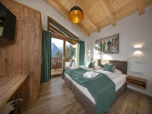 a bedroom with a bed and a large window at Alpine Chalet with Ski-In Access in Neukirchen am Großvenediger