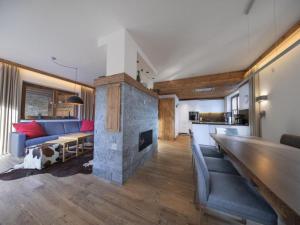 a living room with a blue couch and a fireplace at Alpine Chalet with Ski-In Access in Neukirchen am Großvenediger