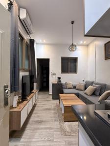 a living room with a couch and a tv at Scenic Tamraght Cozy Studio in Agadir