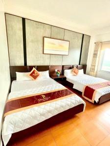 a hotel room with two beds in a room at Đại Việt Hotel in Làng Liễu +7 photos