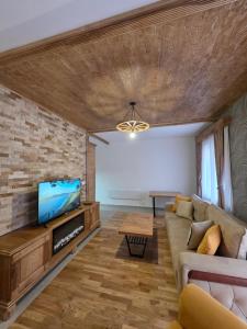 a living room with a couch and a tv at Arija Luxury Suite in Kolašin