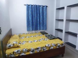 a bedroom with a bed with a yellow comforter at Nomad in Coimbatore