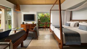 a bedroom with a bed and a couch and a tv at Maya Ubud Resort & Spa in Ubud +55 photos