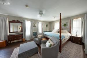 a bedroom with a bed and a chair and a couch at Historic Rider's Hostelry in Painesville