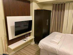a bedroom with a bed and a flat screen tv at Ann's Haven in Cebu City