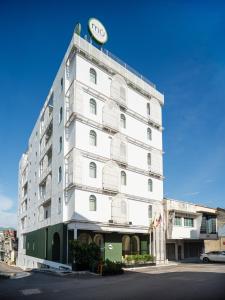 a white building with a clock on top of it at mu petite in Ipoh