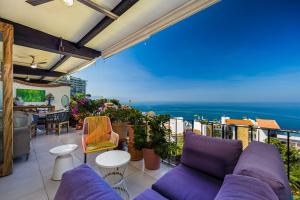 a balcony with purple furniture and a view of the ocean at Charming condo featuring ocean views, pool & private terrace in Puerto Vallarta