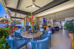 a patio with blue chairs and a table with flowers at Charming condo featuring ocean views, pool & private terrace in Puerto Vallarta