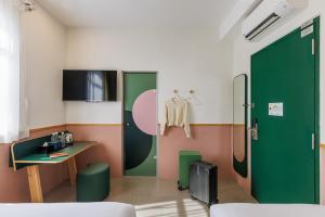 a room with a desk and a green door at mu petite in Ipoh +14 photos