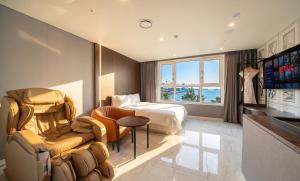 a hotel room with a bedroom with a bed and a couch at Restia Incheon Bay Hotel in Incheon