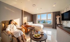 a woman is sitting in a hotel room at Restia Incheon Bay Hotel in Incheon +93 photos