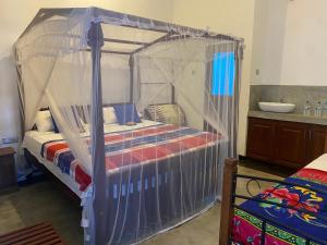 a bed with a canopy in a room at Neo Grand Villa in Galle