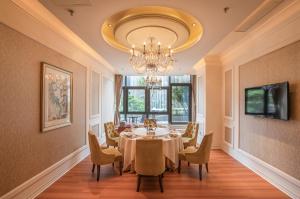 a dining room with a table and chairs and a chandelier at Lia Charlton Hotel Shenzhen in Shenzhen