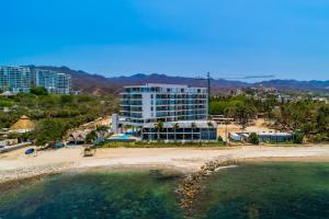 a view of a beach with a large building at Oceanfront Gem with Bay View Terrace & Direct Sea Access in Cruz de Huanacaxtle