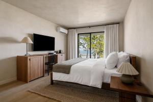 a bedroom with a large bed and a television at The Herondale Hotel in Astoria, Oregon