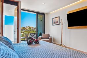 a bedroom with a bed and a tv and a chair at Oceanfront Gem with Bay View Terrace & Direct Sea Access in Cruz de Huanacaxtle