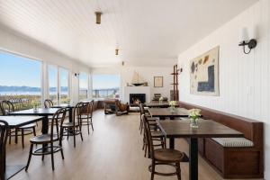 a dining room with tables and chairs and a fireplace at The Herondale Hotel in Astoria, Oregon