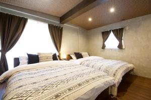 a bedroom with two beds and a window at Fukugi Beach Villa Okinawa in Nakijin