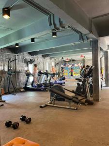 a gym with several tread machines and people in the background at Cozy 1-Bedroom Apartment Near Fisherman's Village in Nathon Bay