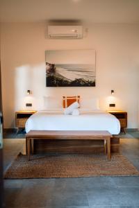 a bedroom with a large bed with a painting on the wall at Co Day Uluwatu Boutique Stays in Uluwatu +45 photos