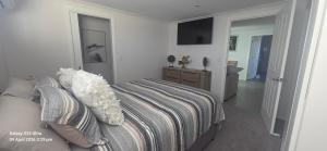 a bedroom with a bed and a bathroom with a television at Oscar's at Banora in Kurrara