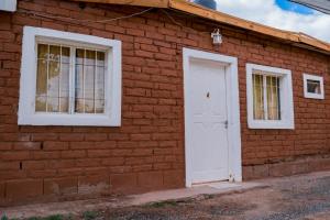 a brick building with a white door and windows at Cabañas de Campo in Villa Unión