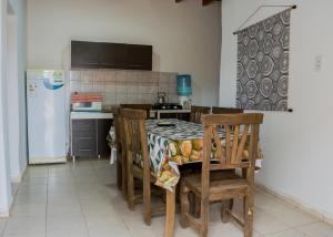 a kitchen with a table with chairs and a refrigerator at Cabañas de Campo in Villa Unión