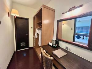 a room with a desk with a mirror and a window at Tunamaya Beach & Spa Resort Tioman Island in Tioman Island