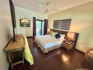 a hotel room with a bed and a table with a lamp at Tunamaya Beach & Spa Resort Tioman Island in Tioman Island +108 photos
