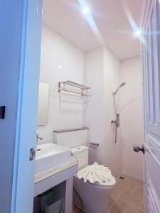 a white bathroom with a toilet and a sink at The View Hotel โรงแรมเดอะวิว นครศรีธรรมราช in Nakhon Si Thammarat