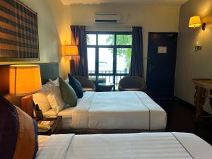 a hotel room with two beds and a window at Tunamaya Beach & Spa Resort Tioman Island in Tioman Island