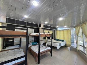 a room with three bunk beds and a room with two beds at Ayenda Balcon Real in Tunja