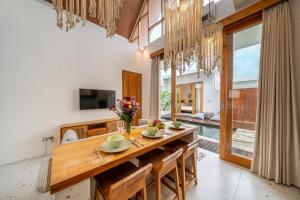 a dining room with a large wooden table and chairs at Sunset Heaven - Private Pool Cozy Villa with Patio in Kerobokan