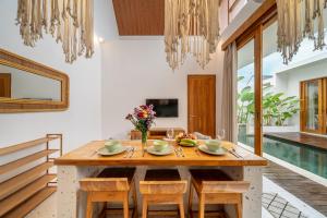 a dining room with a wooden table and chairs at Sunset Heaven - Private Pool Cozy Villa with Patio in Kerobokan