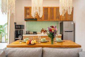a kitchen with a wooden table with a vase of flowers at Sunset Heaven - Private Pool Cozy Villa with Patio in Kerobokan +16 photos