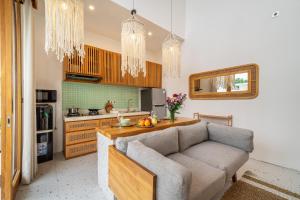 a living room with a couch and a kitchen at Sunset Heaven - Private Pool Cozy Villa with Patio in Kerobokan