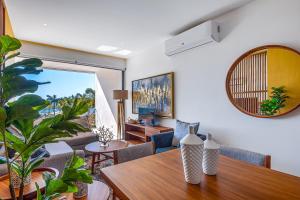 a dining room with a table and a living room at Oceanfront condo with a full kitchen, pool, & beach access in Nuevo Vallarta
