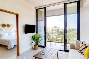 a living room with a bed and a couch and a tv at Ocean-view condo with infinity pool, rooftop lounge, & private balcony in Bucerías