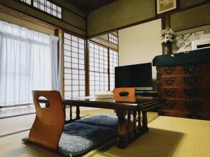 a room with a desk with a computer and a chair at 直島古民家一棟貸し笑くんNaoshima 'Shoukun' Entire house in Naoshima